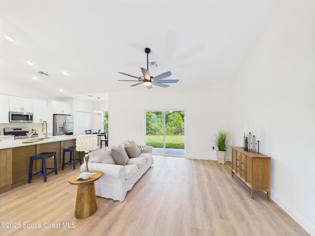 8126 97th Ave, Vero Beach, FL 32967 - living room with light wood-style floors, vaulted ceiling, ceiling fan, baseboards, and recessed lighting