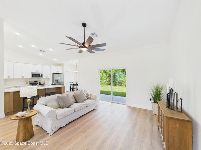 8126 97th Ave, Vero Beach, FL 32967 - living room with ceiling fan, light wood-style floors, vaulted ceiling, baseboards, and recessed lighting