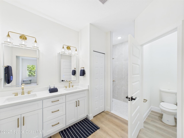 8126 97th Ave, Vero Beach, FL 32967 - bathroom with wood finished floors, walk in shower, double vanity, toilet, and baseboards