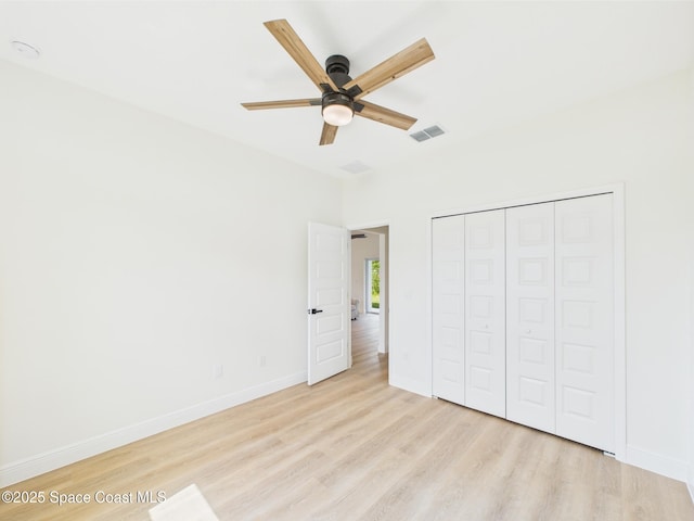 8126 97th Ave, Vero Beach, FL 32967 - unfurnished bedroom with light wood finished floors, baseboards, a closet, and a ceiling fan