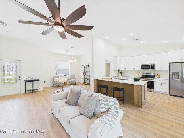8126 97th Ave, Vero Beach, FL 32967 - living room featuring light wood finished floors, a ceiling fan, a chandelier, recessed lighting, and baseboards