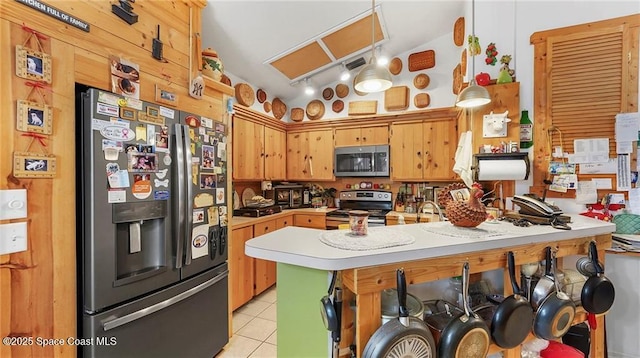 8516 99th Ct, Vero Beach, FL 32967 - kitchen featuring appliances with stainless steel finishes, vaulted ceiling, light tile patterned flooring, a peninsula, and light countertops