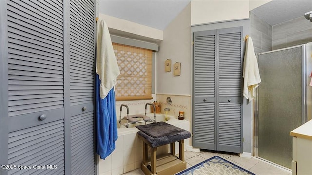 8516 99th Ct, Vero Beach, FL 32967 - bathroom featuring a closet, tile patterned flooring, a stall shower, and a bathtub