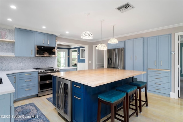 1951 W Sandpiper Rd, Vero Beach, FL 32963 - kitchen with open shelves, appliances with stainless steel finishes, beverage cooler, blue cabinetry, and crown molding