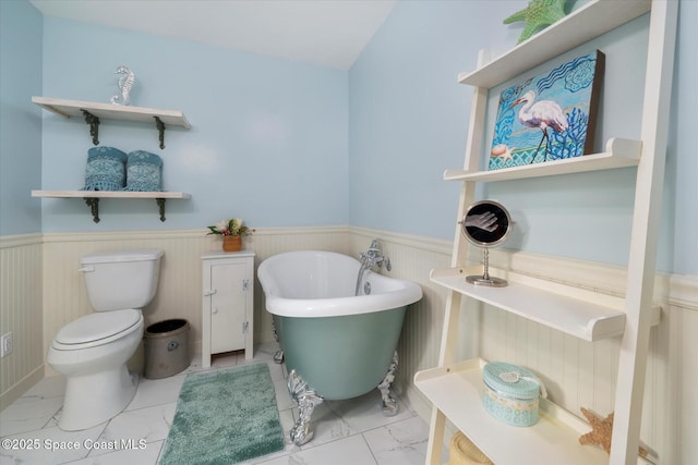 1951 W Sandpiper Rd, Vero Beach, FL 32963 - bathroom with a wainscoted wall, marble finish flooring, toilet, and a freestanding tub