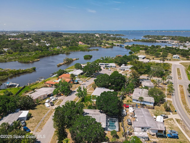 aerial view of property's location featuring a nearby body of water and nearby suburban area
