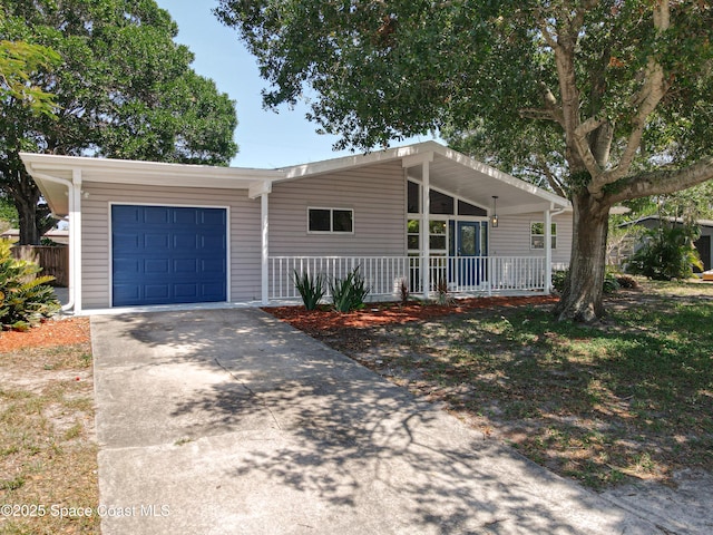 mid-century modern home with a garage, concrete driveway, and covered porch