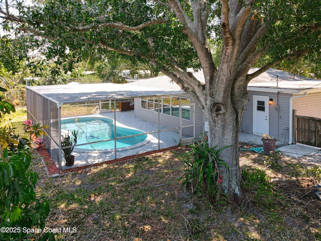 swimming pool featuring a patio area, fence, a lanai, and a sunroom