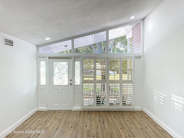 entrance foyer featuring a textured ceiling, baseboards, and light wood-style flooring