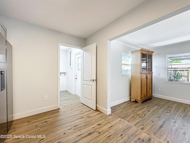 empty room featuring light wood-style floors and baseboards
