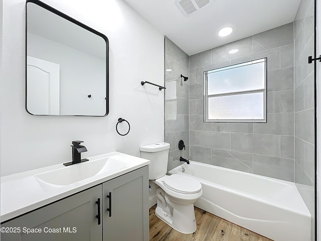 bathroom with vanity, toilet, wood finished floors, and tub / shower combination