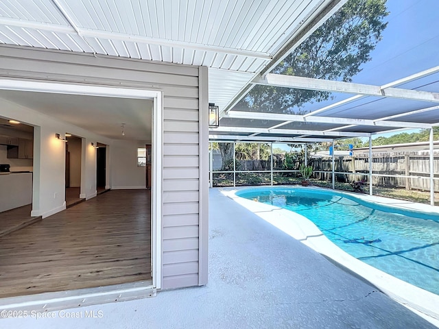 view of pool with a fenced backyard, a lanai, and a patio area