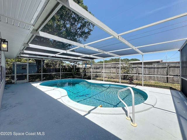 view of swimming pool with a patio, a fenced backyard, and a lanai