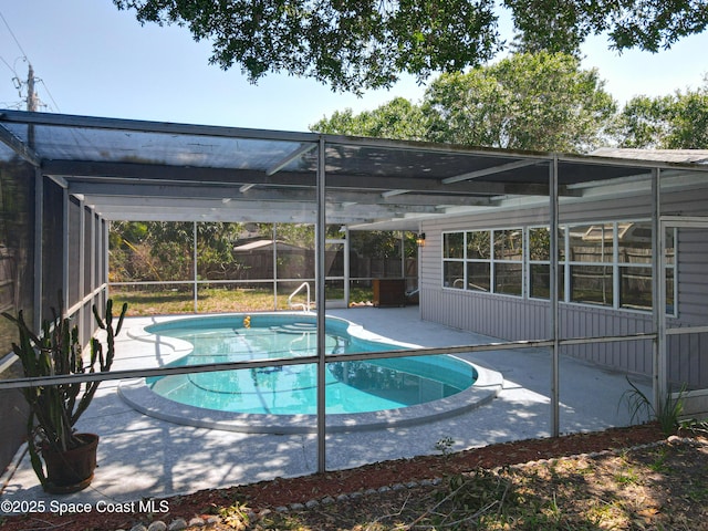 view of pool featuring a patio area, fence, and glass enclosure
