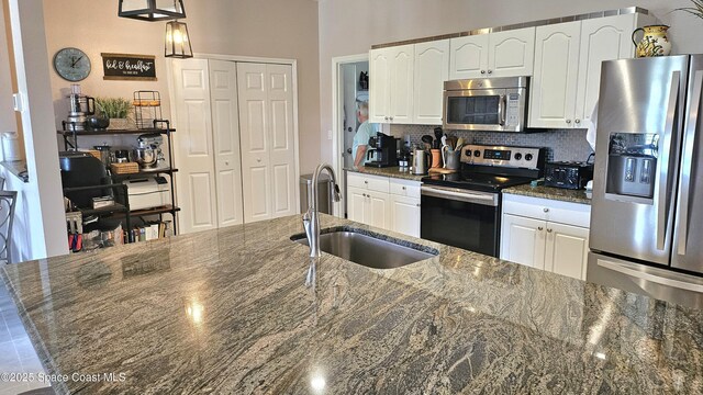 5290 Cinnamon Fern Blvd, Cocoa, FL 32927 - kitchen featuring stainless steel appliances, a sink, white cabinets, and dark stone counters