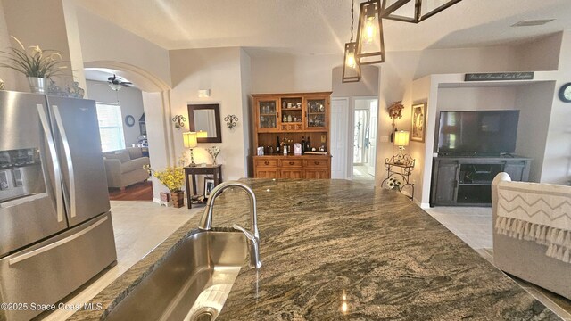 5290 Cinnamon Fern Blvd, Cocoa, FL 32927 - kitchen featuring stainless steel fridge, ceiling fan, a sink, arched walkways, and dark stone countertops