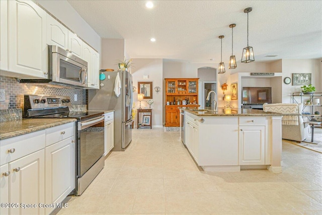 5290 Cinnamon Fern Blvd, Cocoa, FL 32927 - kitchen with stainless steel appliances, decorative backsplash, white cabinetry, light stone countertops, and recessed lighting