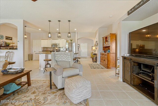 5290 Cinnamon Fern Blvd, Cocoa, FL 32927 - living room with light tile patterned floors, arched walkways, and recessed lighting