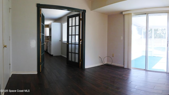 1581 Charles Blvd NE, Palm Bay, FL 32907 - empty room with healthy amount of natural light, dark wood-style flooring, and baseboards