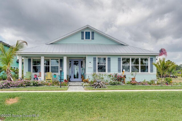 5250 Riveredge Dr, Titusville, FL 32780 - view of front of home featuring a front yard, a porch, and metal roof