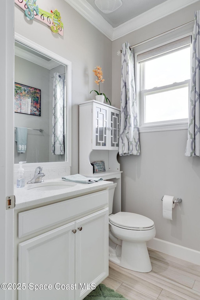 5250 Riveredge Dr, Titusville, FL 32780 - bathroom with toilet, crown molding, vanity, baseboards, and wood finished floors