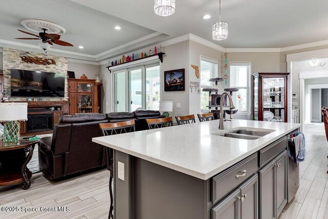 5250 Riveredge Dr, Titusville, FL 32780 - kitchen with open floor plan, a sink, gray cabinetry, light wood finished floors, and an island with sink