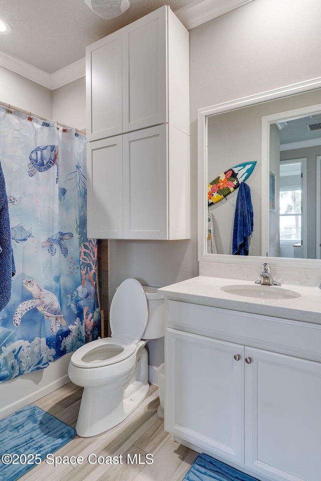 5250 Riveredge Dr, Titusville, FL 32780 - full bath with crown molding, wood finished floors, vanity, toilet, and shower / bathtub combination with curtain