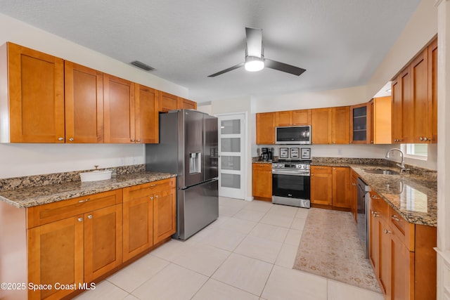 2007 Oak St, Melbourne Beach, FL 32951 - kitchen featuring stainless steel appliances, a sink, dark stone countertops, and brown cabinetry