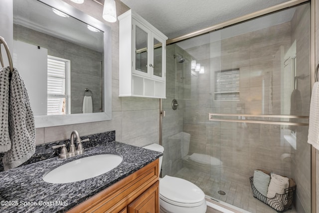 2007 Oak St, Melbourne Beach, FL 32951 - full bath featuring toilet, a shower stall, vanity, and tile walls