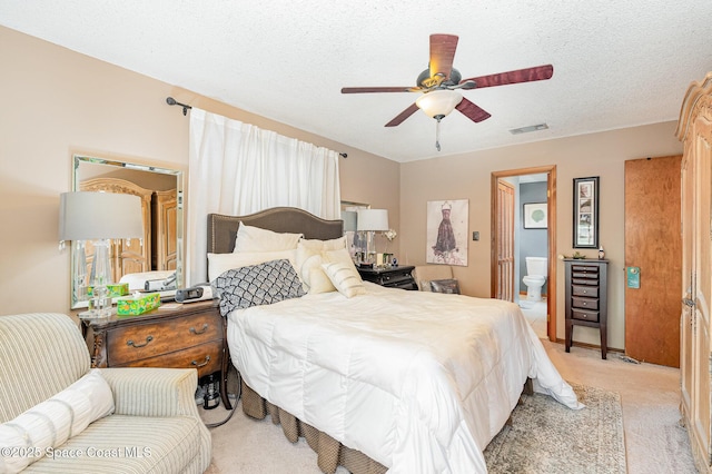 6855 Bryant Rd, Cocoa, FL 32927 - bedroom featuring light colored carpet, connected bathroom, ceiling fan, and a textured ceiling