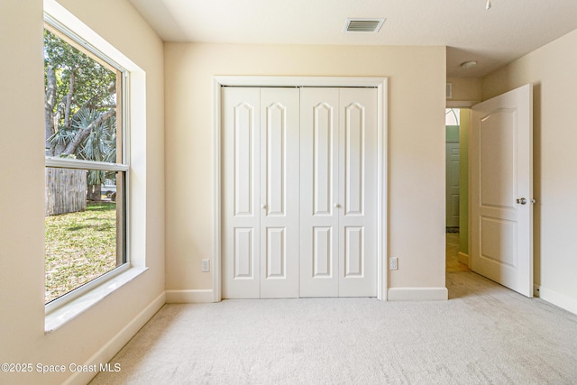 854 Belhurst Ln, Rockledge, FL 32955 - unfurnished bedroom with a closet, multiple windows, carpet flooring, and baseboards
