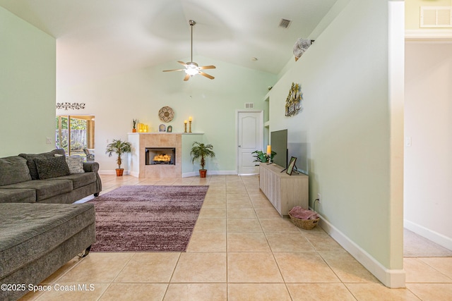 854 Belhurst Ln, Rockledge, FL 32955 - living room featuring light tile patterned floors, a ceiling fan, a tiled fireplace, high vaulted ceiling, and baseboards