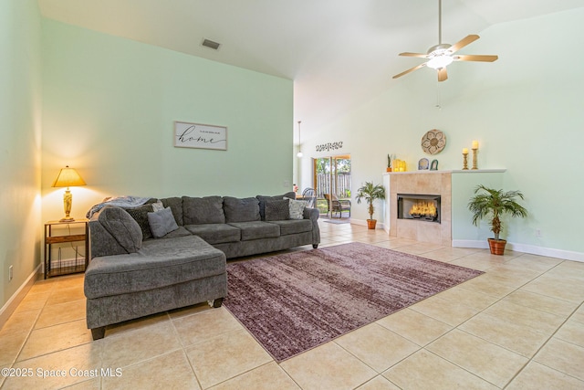854 Belhurst Ln, Rockledge, FL 32955 - living area with tile patterned flooring, ceiling fan, vaulted ceiling, a fireplace, and baseboards