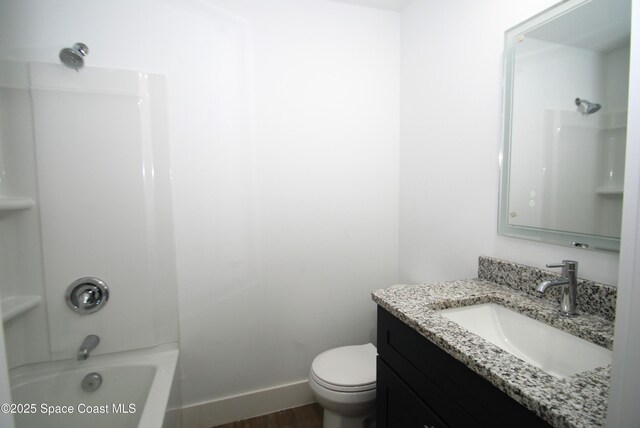 1558 Pentax Ave, Titusville, FL 32796 - bathroom featuring vanity, wood finished floors, toilet, shower / tub combination, and baseboards