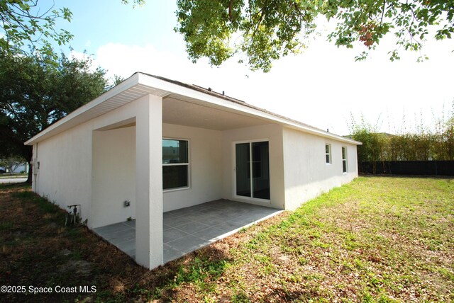 1558 Pentax Ave, Titusville, FL 32796 - rear view of house with stucco siding and a patio