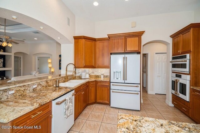 4178 Ventana Blvd, Rockledge, FL 32955 - kitchen with white appliances, a sink, light stone counters, light tile patterned flooring, and a ceiling fan