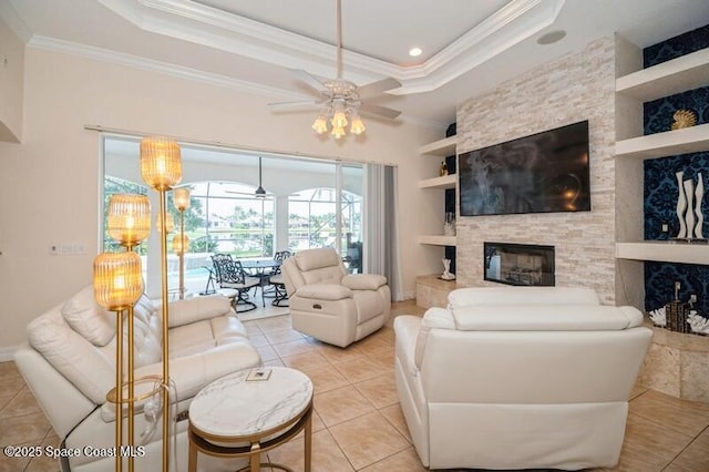 4178 Ventana Blvd, Rockledge, FL 32955 - living area with crown molding, ceiling fan, a tray ceiling, light tile patterned floors, and a fireplace