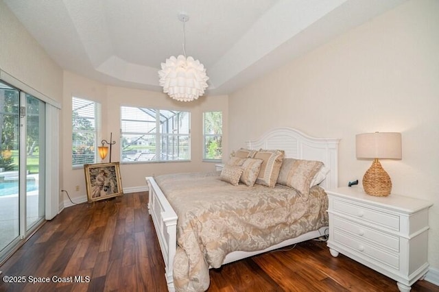 4178 Ventana Blvd, Rockledge, FL 32955 - bedroom featuring dark wood-type flooring, access to exterior, a chandelier, a tray ceiling, and baseboards