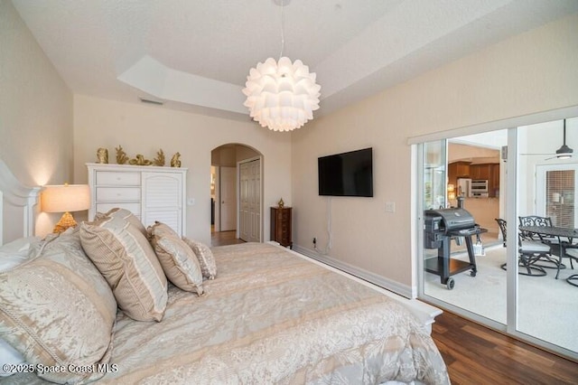 4178 Ventana Blvd, Rockledge, FL 32955 - bedroom with arched walkways, wood finished floors, a chandelier, and a tray ceiling
