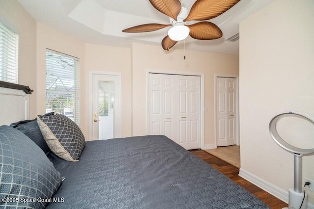 4178 Ventana Blvd, Rockledge, FL 32955 - bedroom with dark wood finished floors, two closets, a ceiling fan, and baseboards