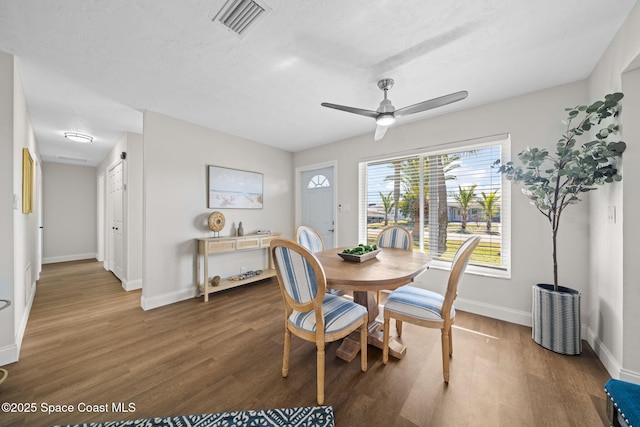 dining space with wood finished floors, baseboards, and a ceiling fan