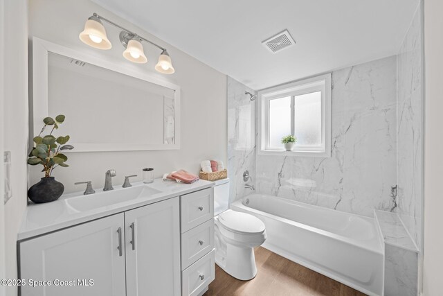 full bathroom featuring toilet, vanity, wood finished floors, and bathtub / shower combination