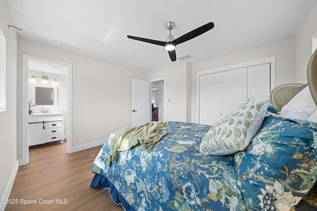 bedroom with wood finished floors, baseboards, a closet, a ceiling fan, and connected bathroom