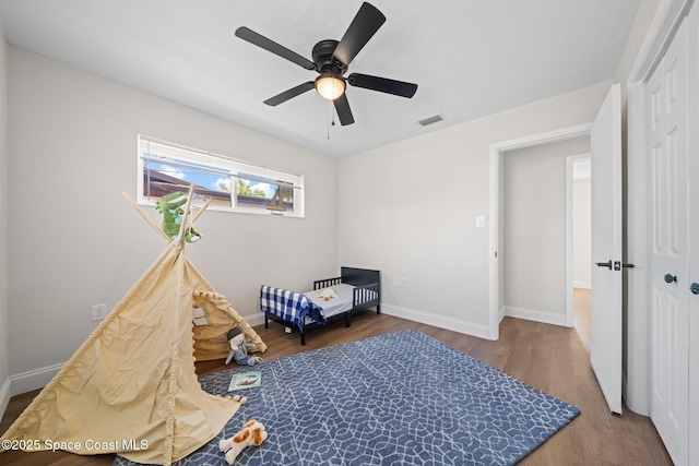 bedroom with wood finished floors, baseboards, a closet, and ceiling fan
