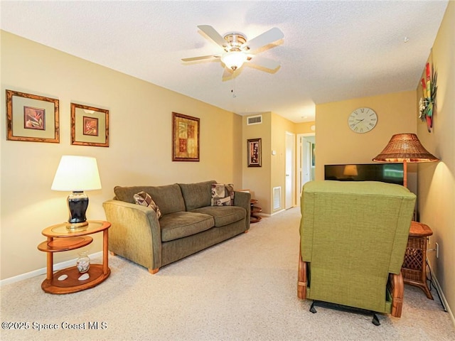 carpeted living room featuring ceiling fan and baseboards