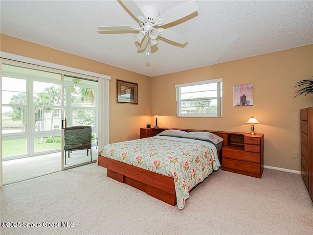 carpeted bedroom with access to exterior, ceiling fan, and baseboards