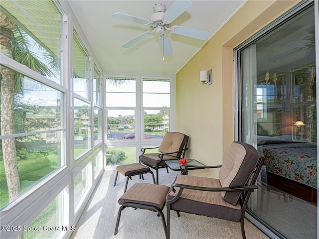 sunroom / solarium featuring healthy amount of natural light and a ceiling fan