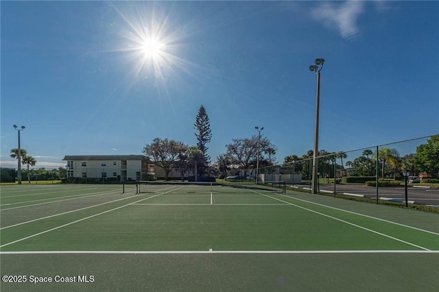 view of tennis court featuring fence