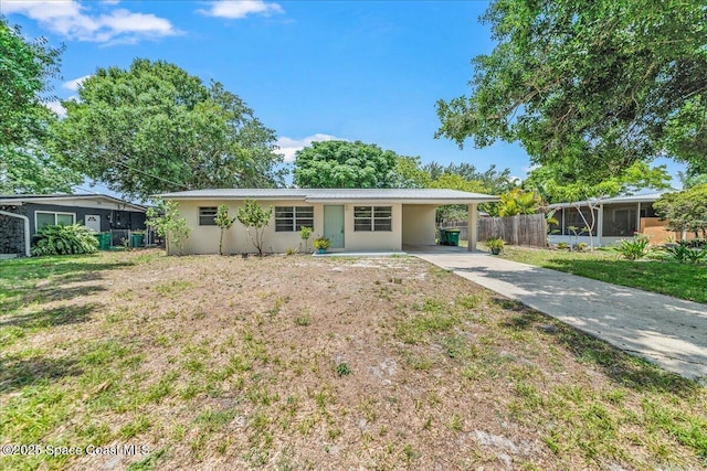 133 Lee Rd, Melbourne, FL 32904 - ranch-style house with driveway, an attached carport, stucco siding, and a sunroom