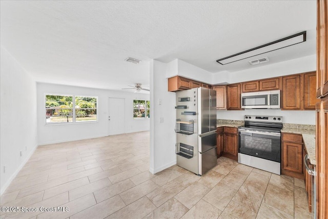 133 Lee Rd, Melbourne, FL 32904 - kitchen featuring stainless steel appliances, open floor plan, brown cabinets, a ceiling fan, and baseboards